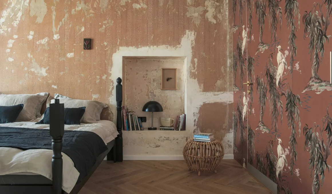 Distressed orange wall and House of Hackney wallpaper in Tbilisi bedroom.