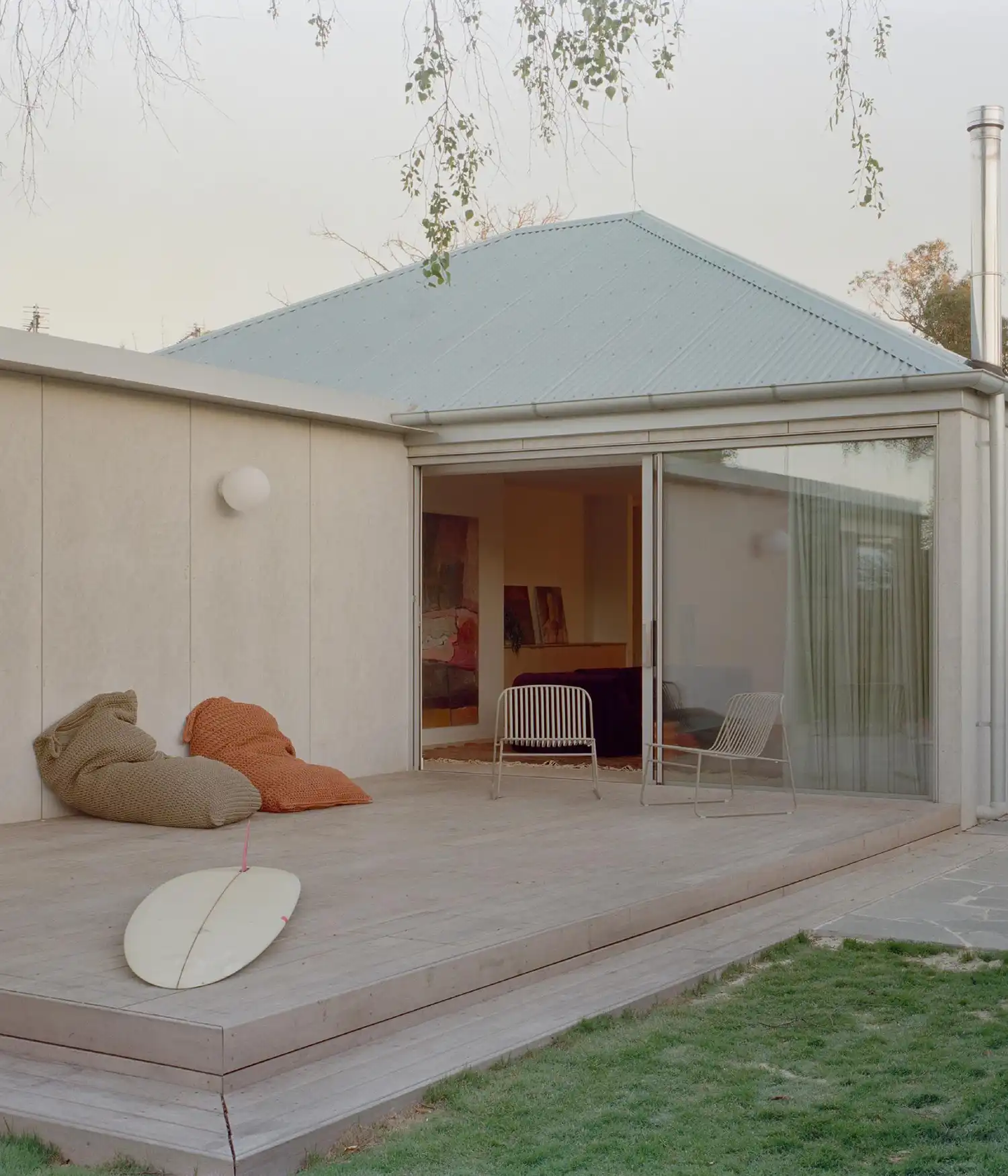 Rear timber deck with large sliding glass doors and outdoor lounge seating.