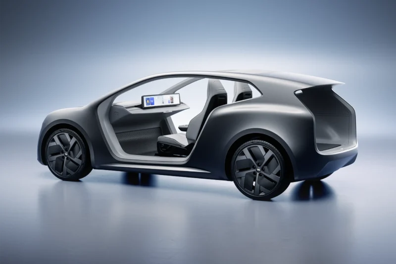 Three-quarter rear view of the silver Lucid Lunar robotaxi concept featuring a minimalist, pillarless side opening and large geometric wheels.