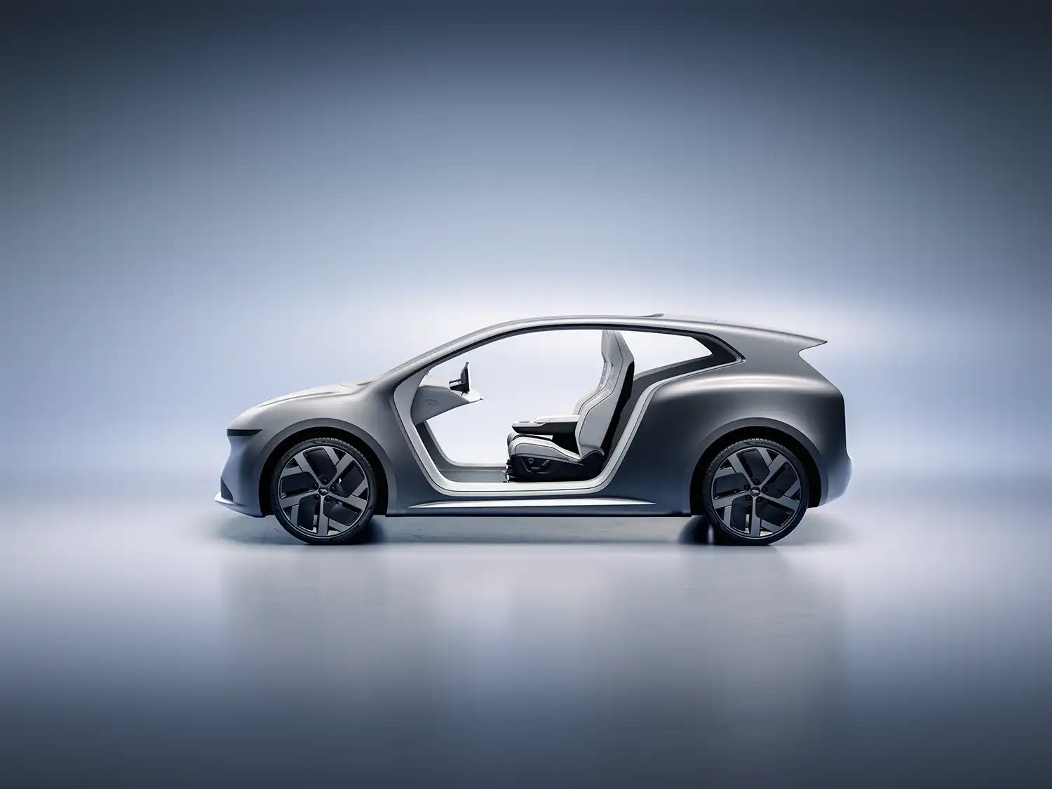 Full side profile of the Lucid Lunar concept vehicle against a soft blue background, illustrating its compact two-seat proportions and sleek roofline.