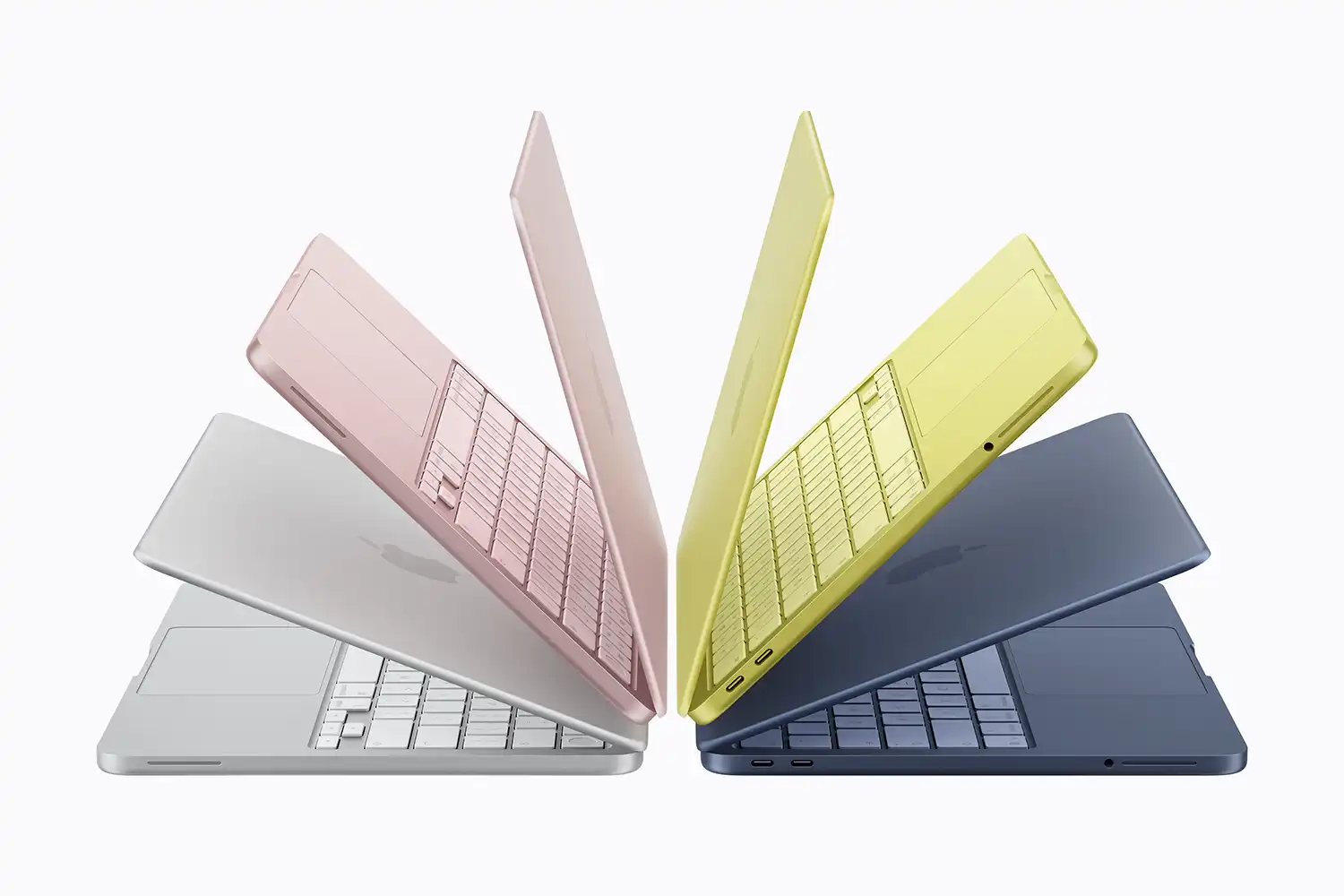 Four MacBook Neo models in silver, blush, citrus, and indigo fanned out.