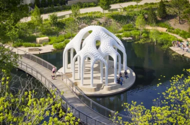 Wide angle view of L’île Folie pavilion on a circular island in Downtown Cary Park with visitors.