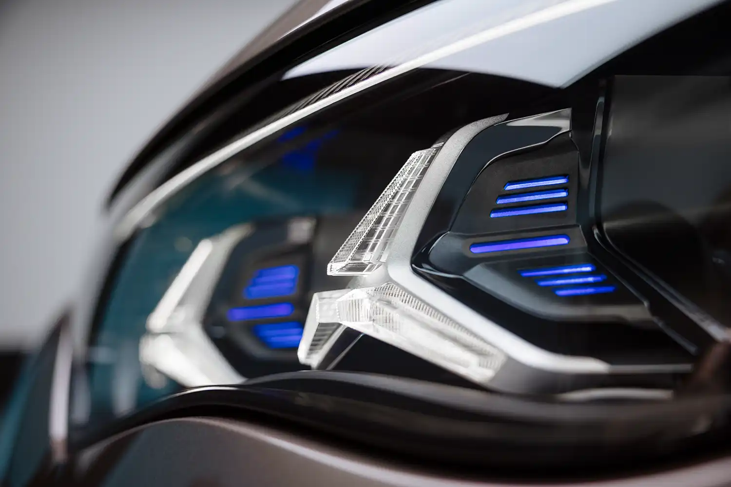 Extreme close-up of the VLE's DIGITAL LIGHT headlight cluster with blue accents.