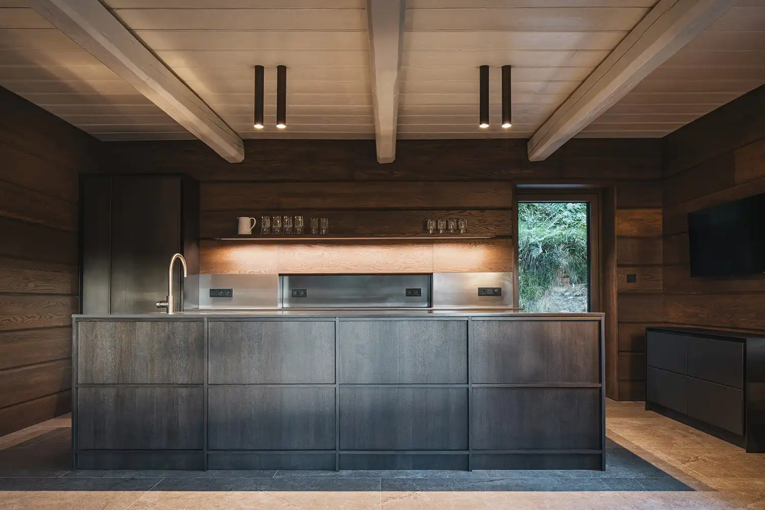 Contemporary kitchen in Strážné Cottage with dark wood cabinetry and a minimalist island.