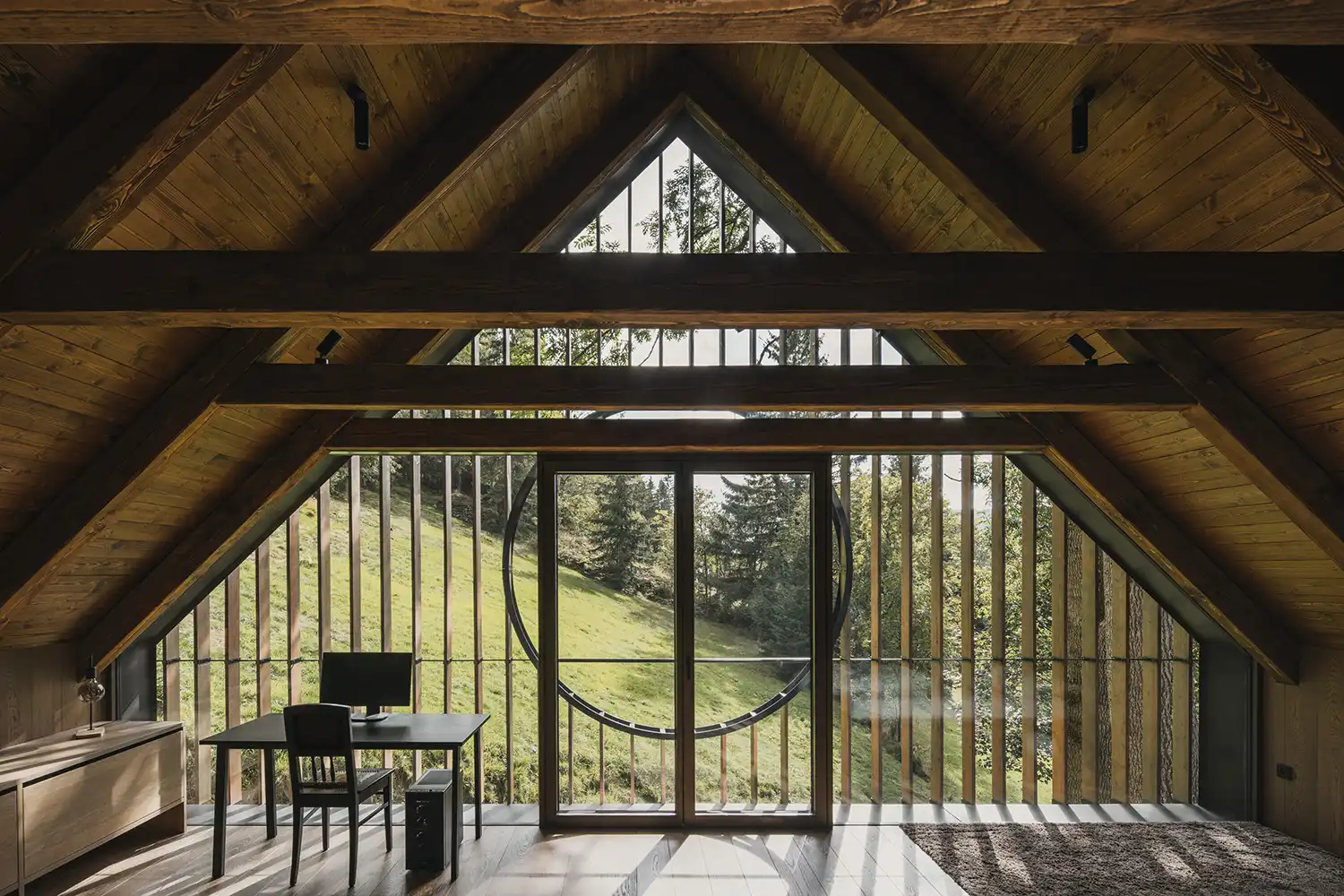 Home office space in the loft featuring a desk and panoramic views through a circular glass detail.