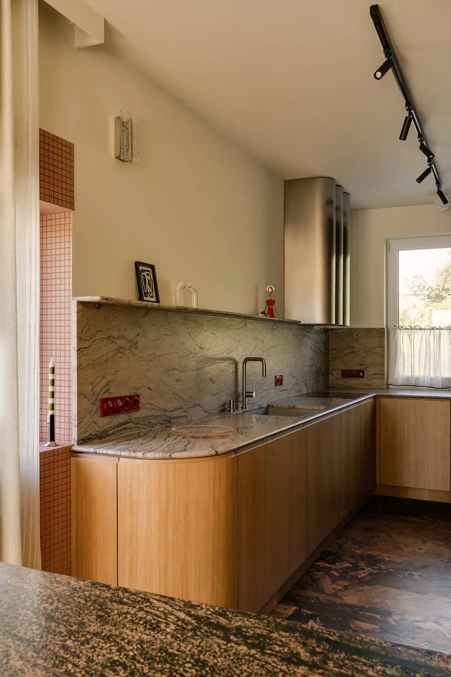 Minimalist kitchen with Prada Gold Granite countertops and a custom curved steel extractor hood.
