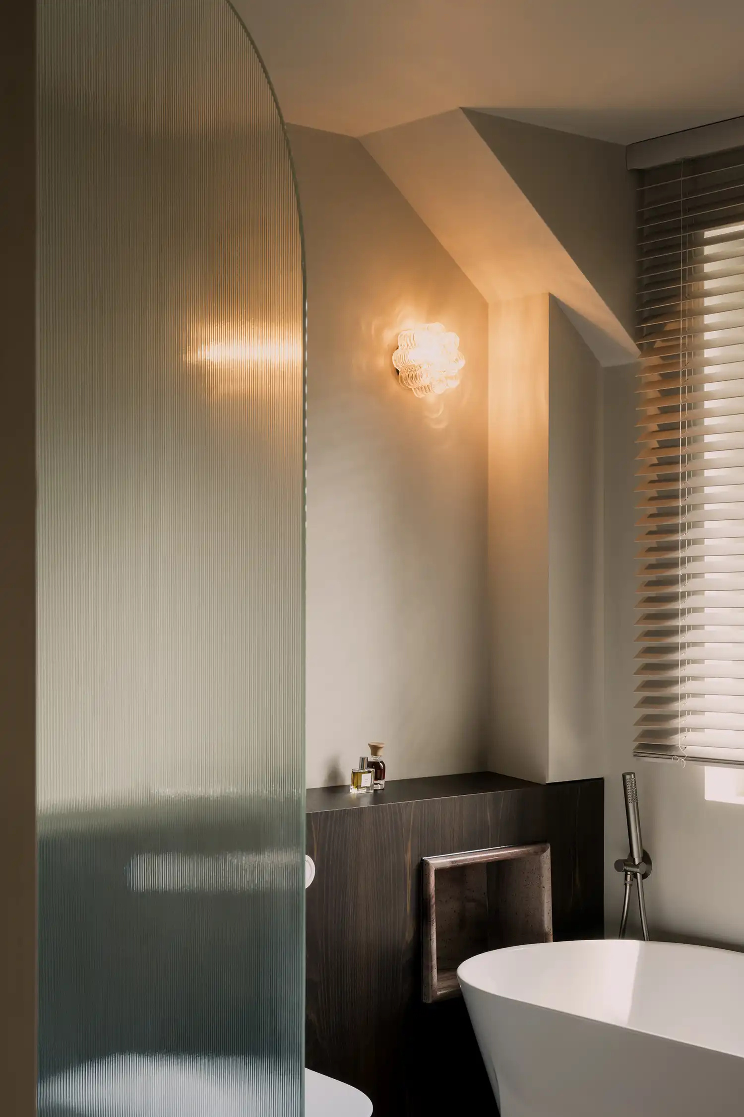 Elegant bathroom with fluted glass shower screen, smoked oak joinery, and a freestanding tub.