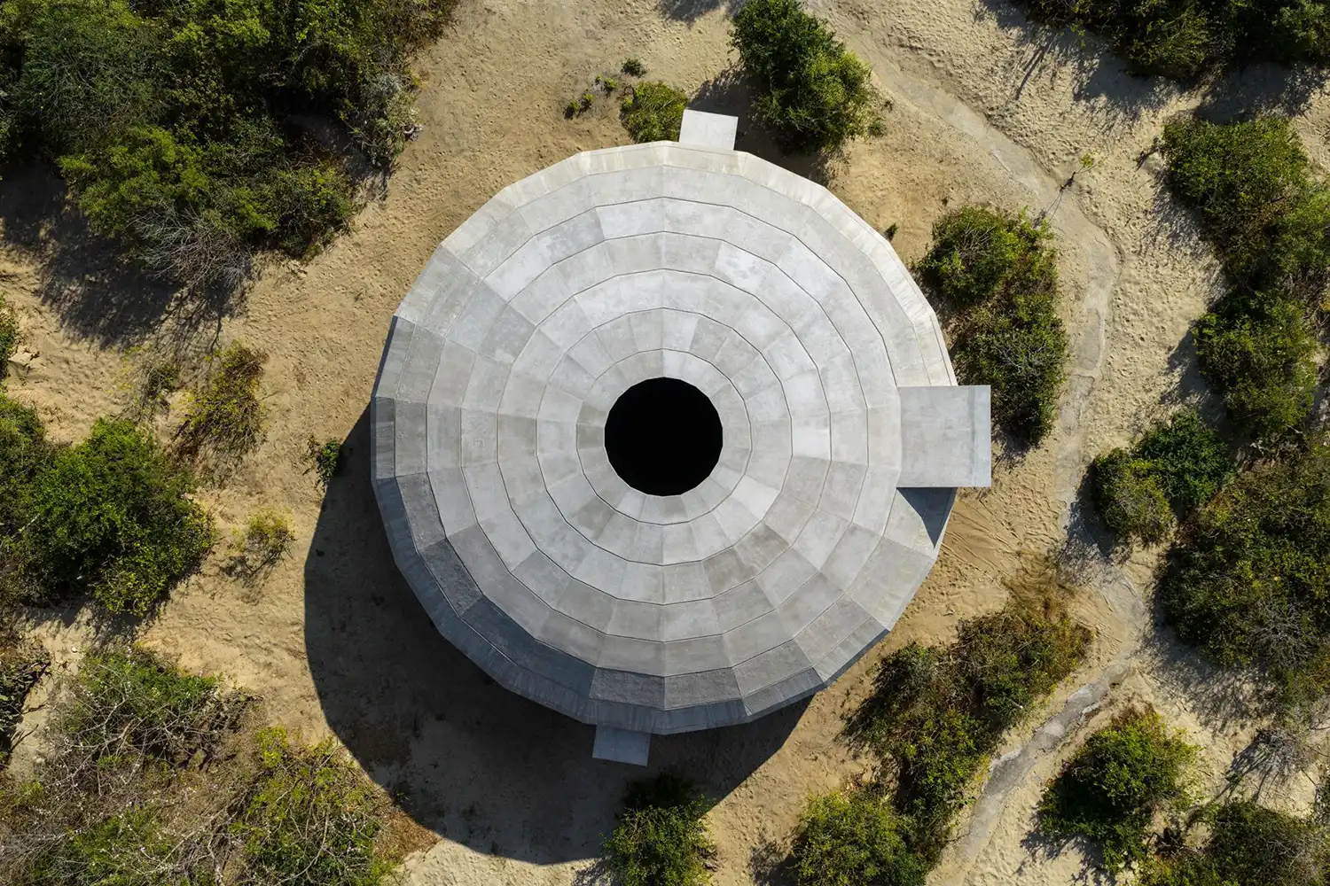 Precise top-down aerial photograph of the circular concrete pavilion and its central oculus