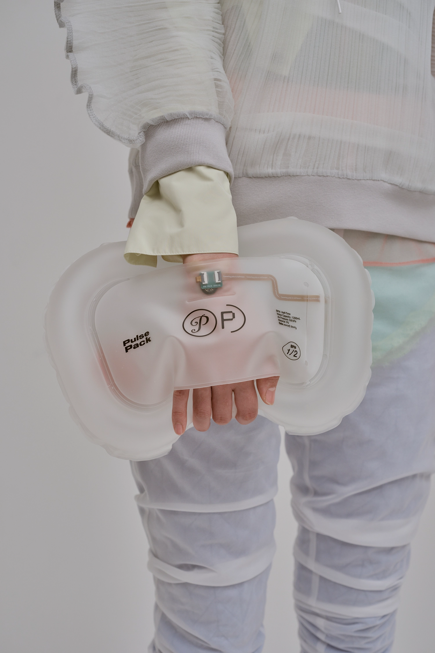 A person carrying the Pulse Pack like a clutch, emphasizing its portability and functional use as a lifestyle accessory.