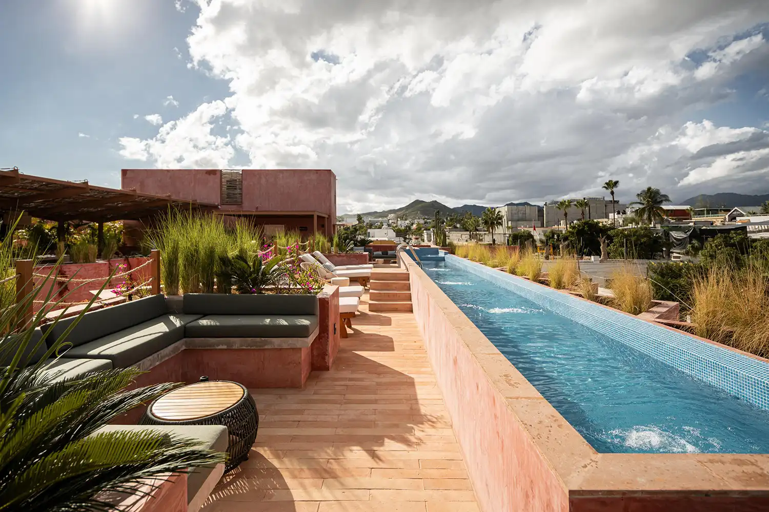 Rooftop infinity pool with mountain views and lounge seating.