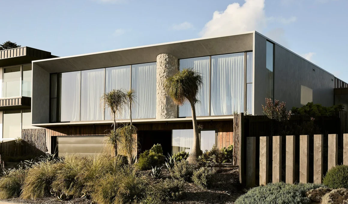 Exterior view of Coastal House by Splinter Society featuring a cantilevered concrete upper floor and recycled timber base.