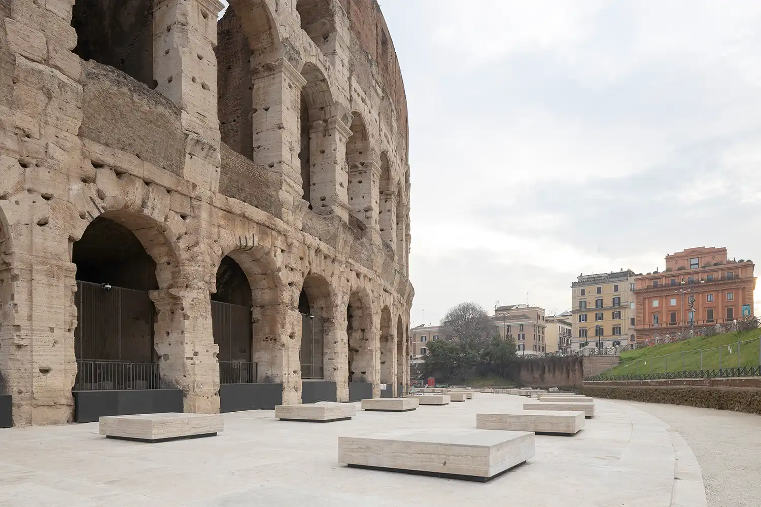 Travertine seating blocks and paving stones in front of the Colosseum arches