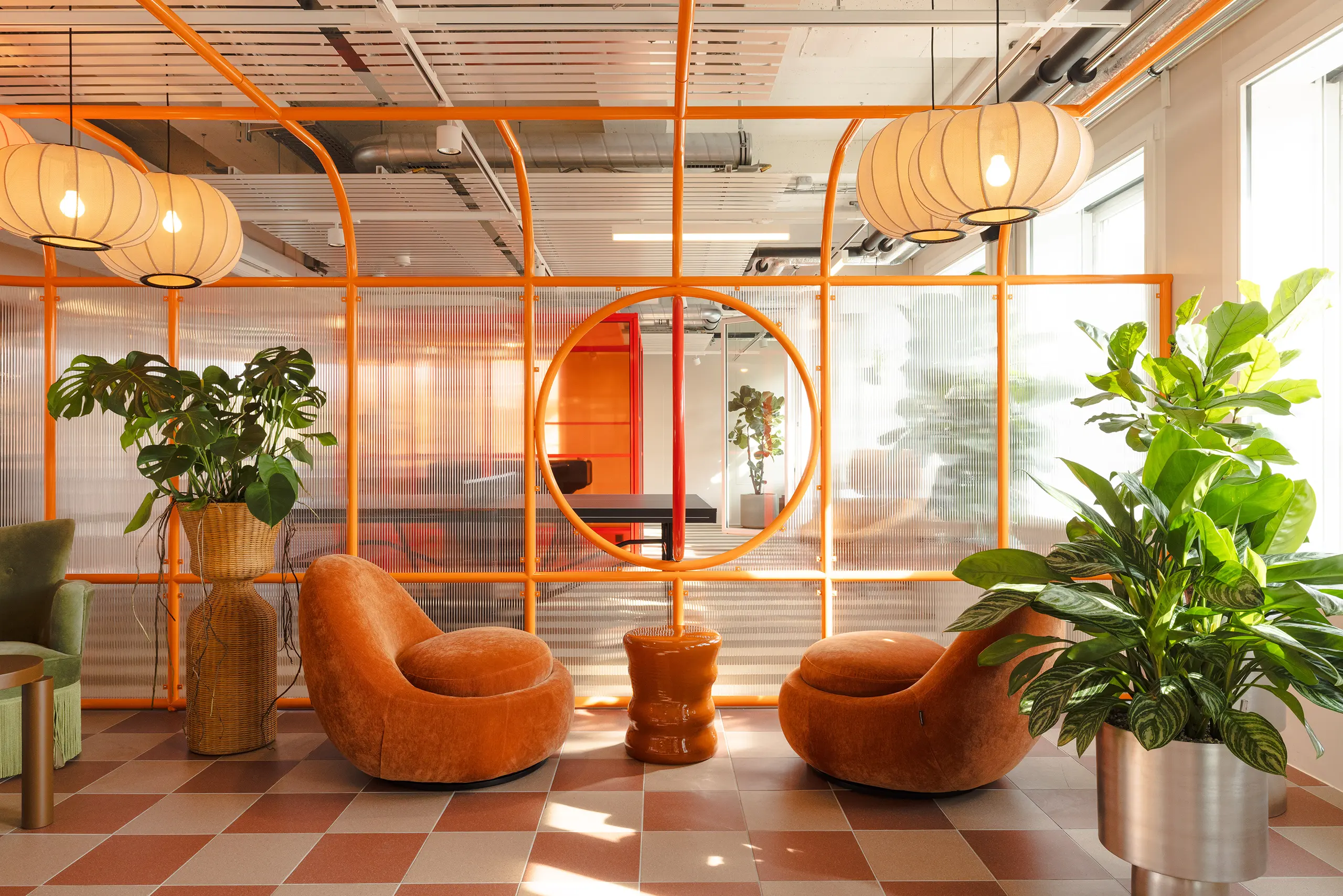 Studio Aisslinger Zurich workspace with orange metal framing and velvet chairs