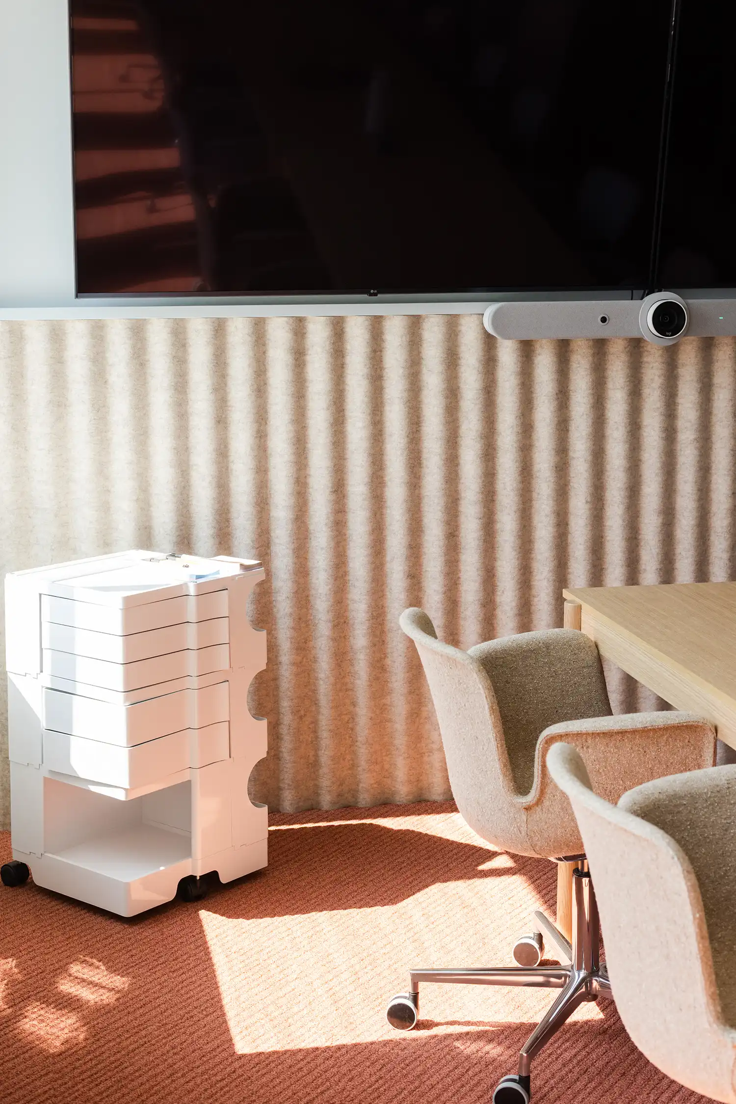 Detail of a corrugated acoustic wall with a white modular storage trolley