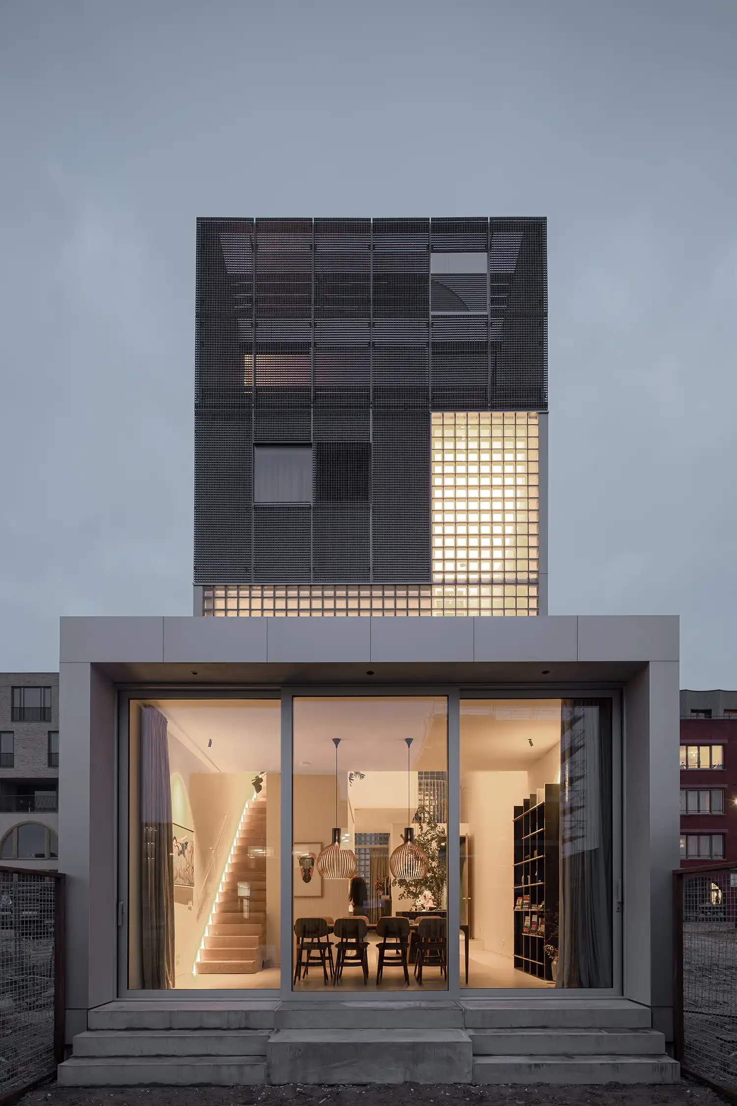 Rear facade of Light House featuring steel grating and a large ground-floor glass sliding door.