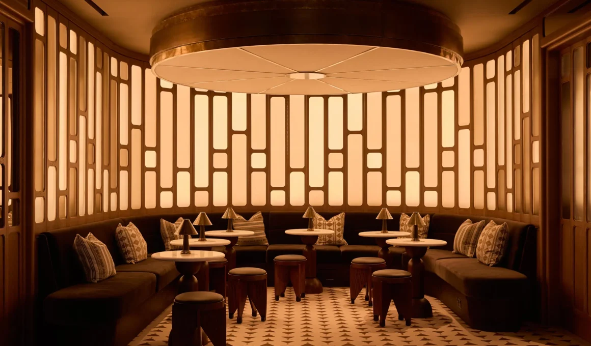 Circular illuminated wall installation and velvet seating in a boutique hotel lounge.