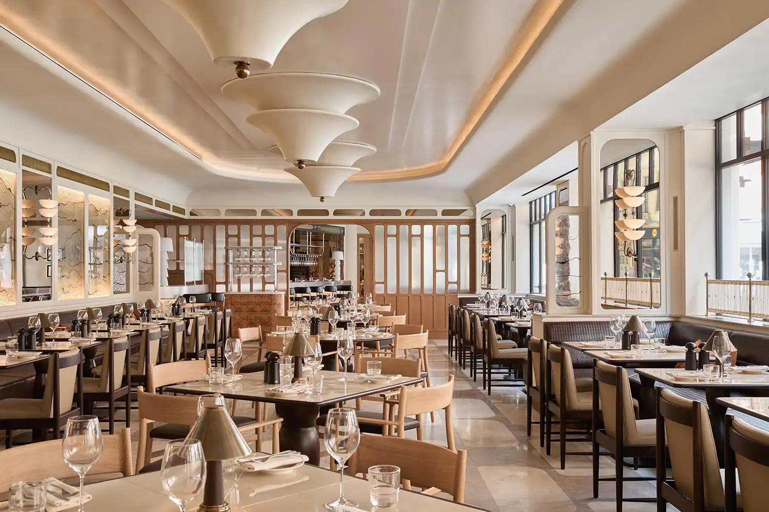 Angelica Brasserie interior with Art Deco lighting and marble tables.