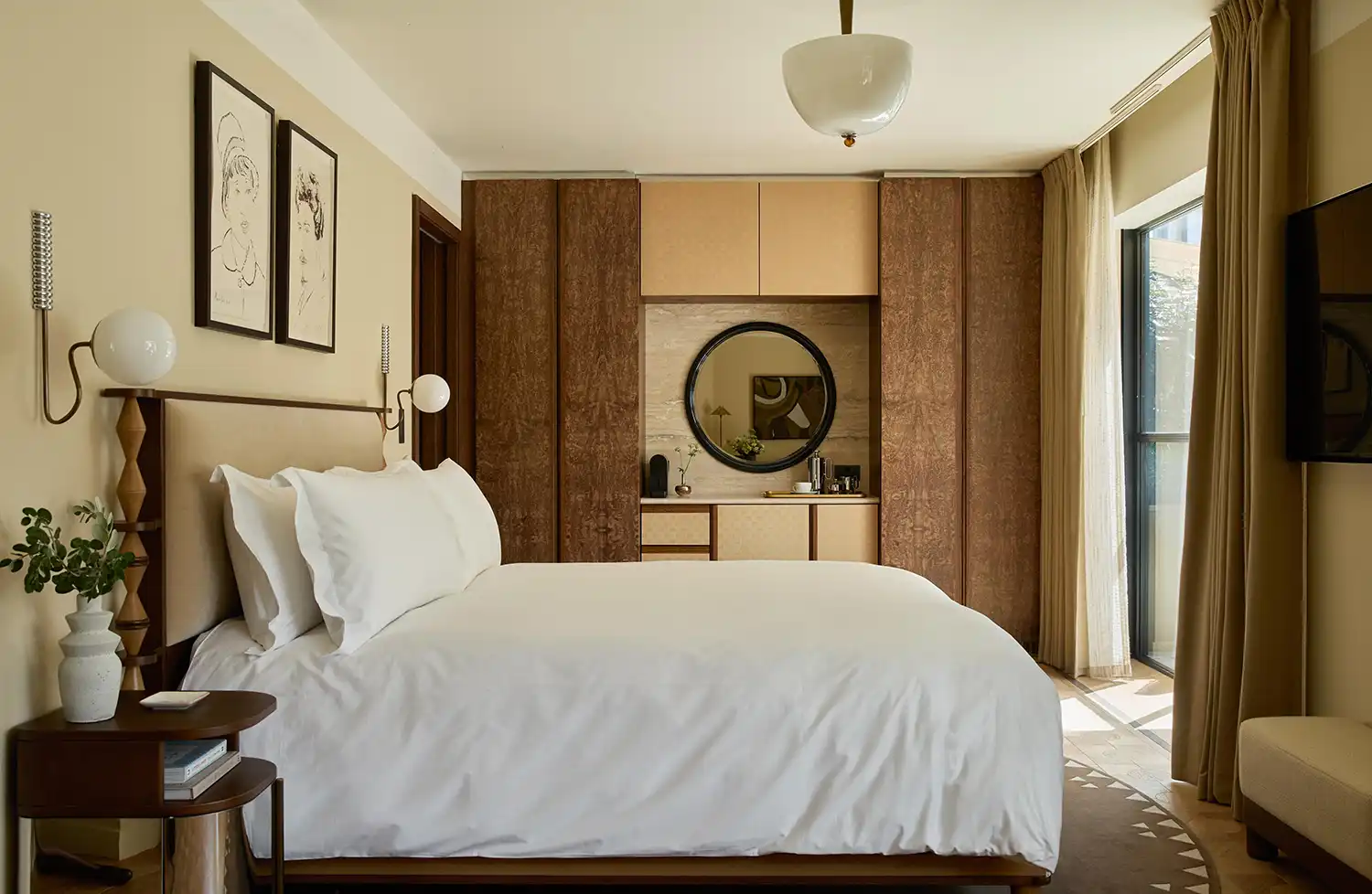Contemporary hotel bedroom with burr wood cabinetry and minimal art.