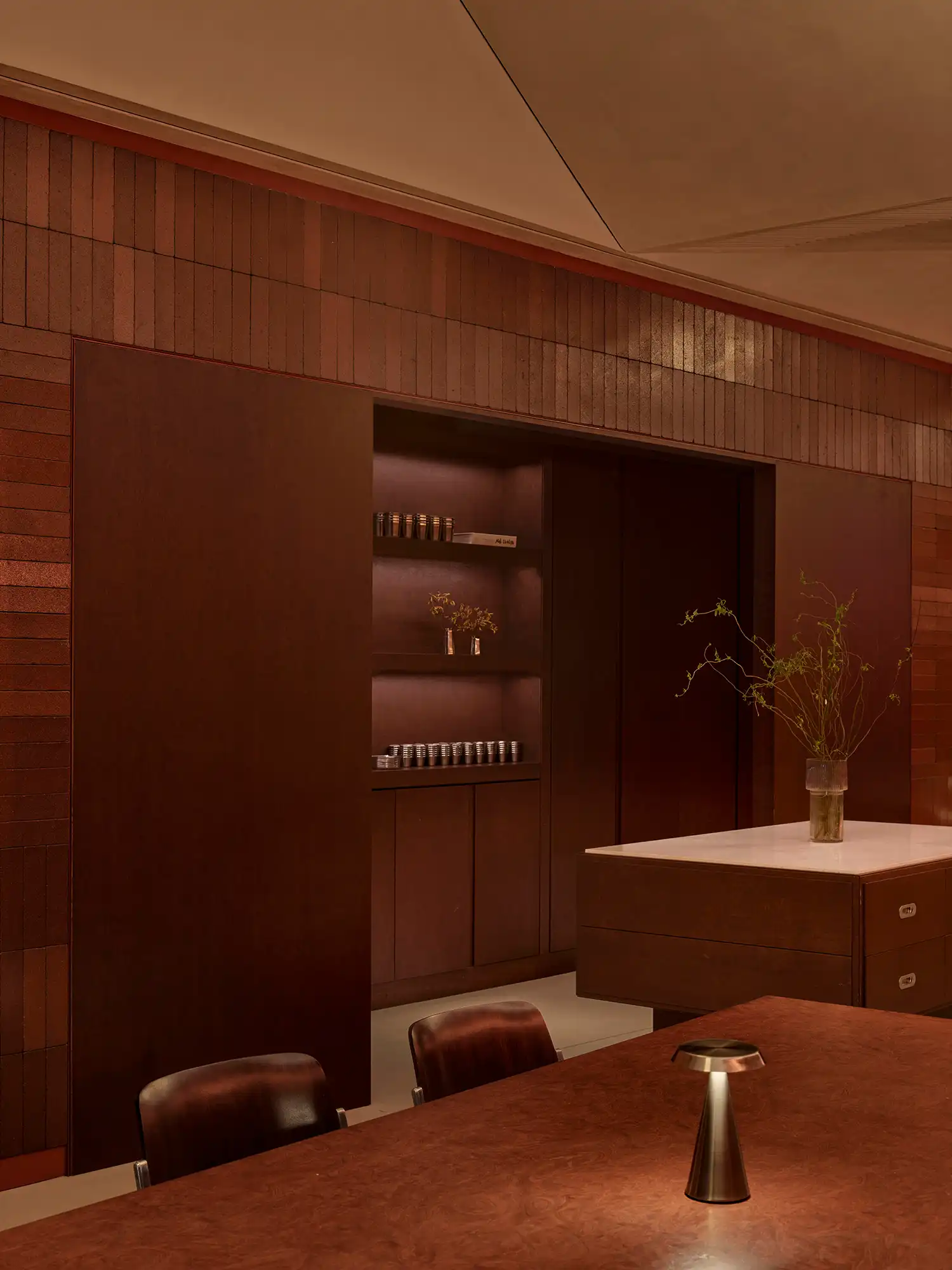 View of the dark wood cabinetry and service island at AINEN burger bar.