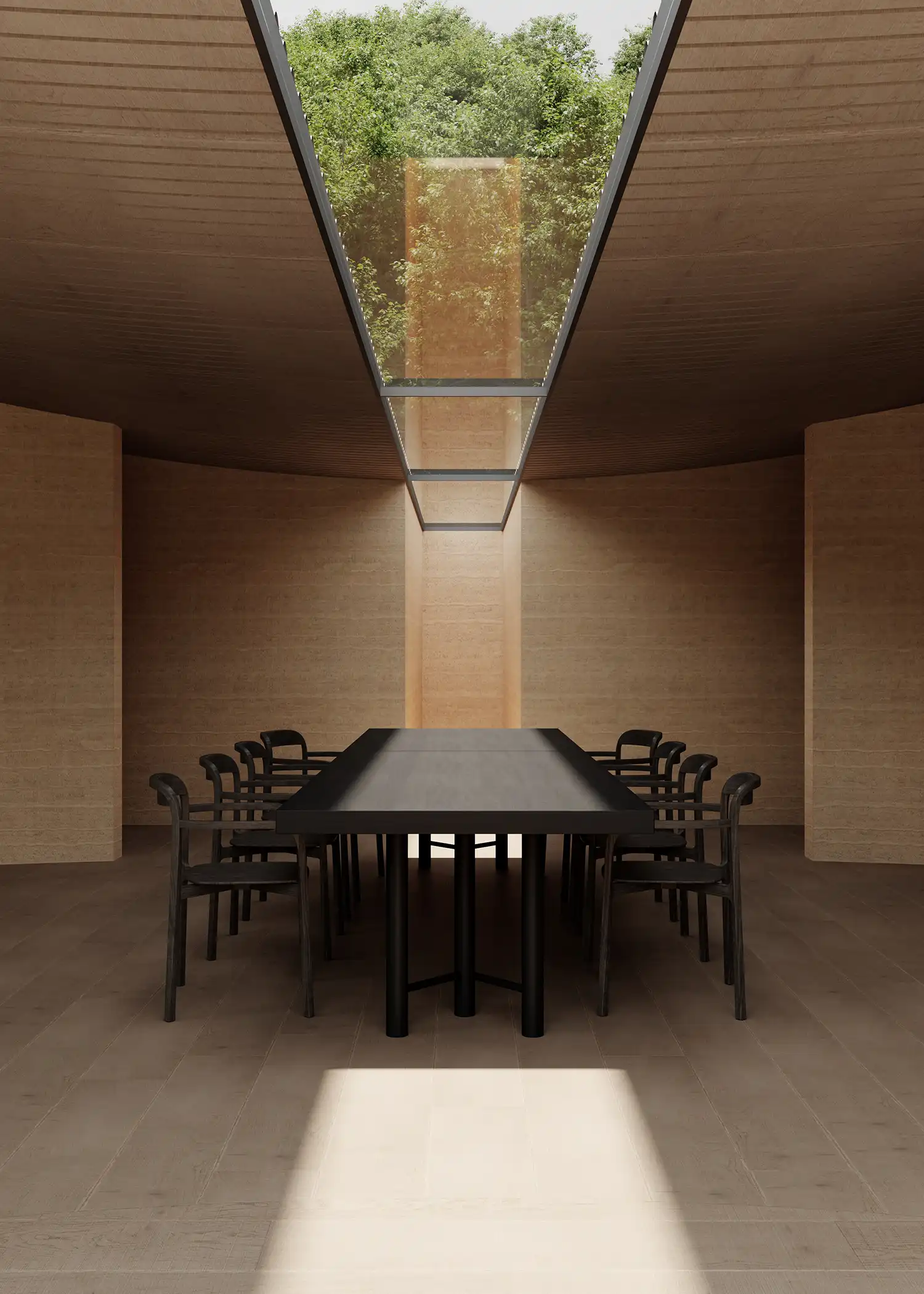 Long black communal dining table centered under a linear glass skylight in a minimalist concrete room.