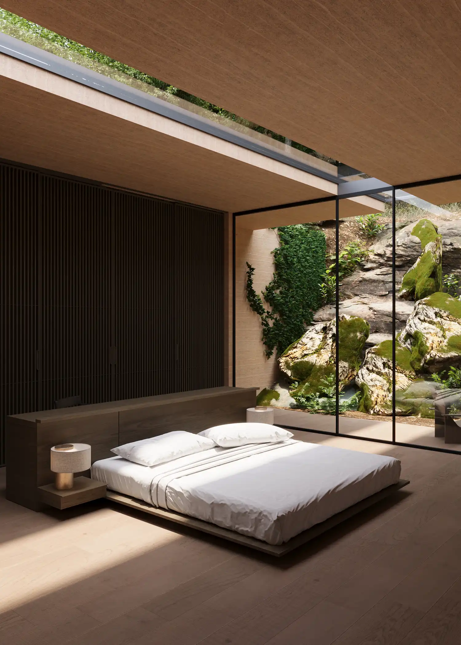 Modern bedroom with a low-profile bed facing a large glass wall that looks onto a mossy rock face.
