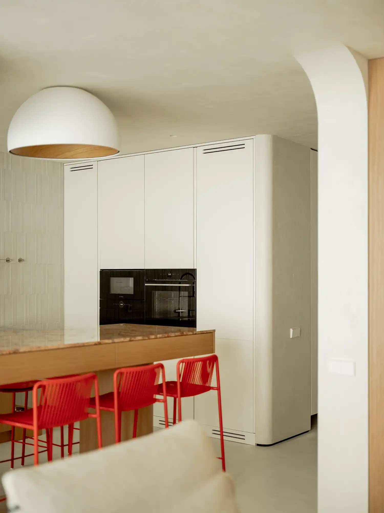 White floor-to-ceiling kitchen cabinets with integrated black appliances.