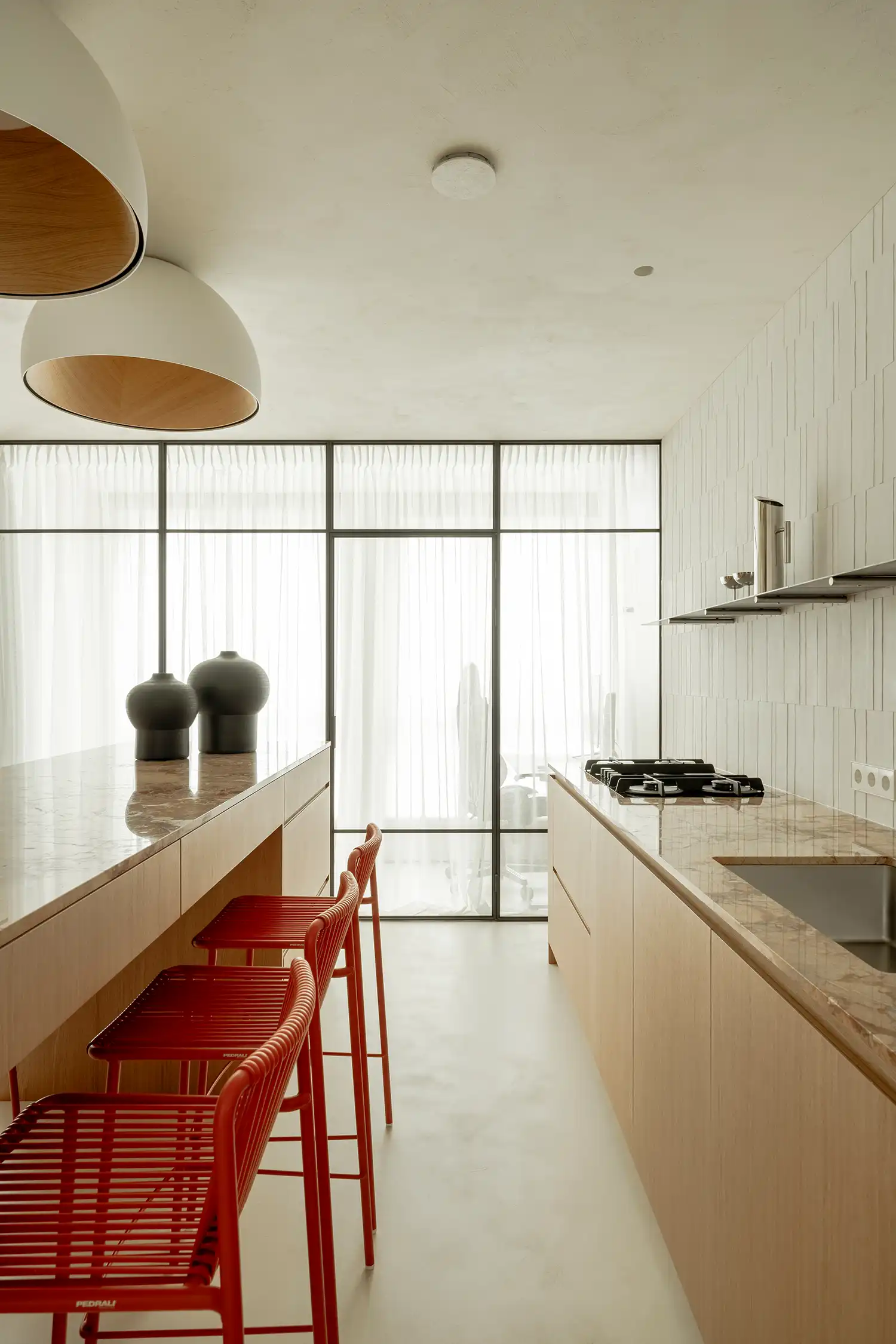 Kitchen workspace with stainless steel shelves and marble countertops.