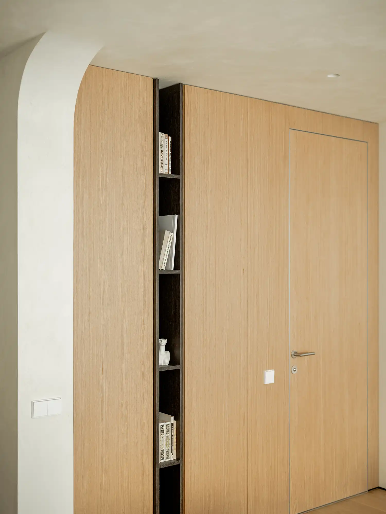 Detail of wooden wall panels with integrated dark wood shelving.