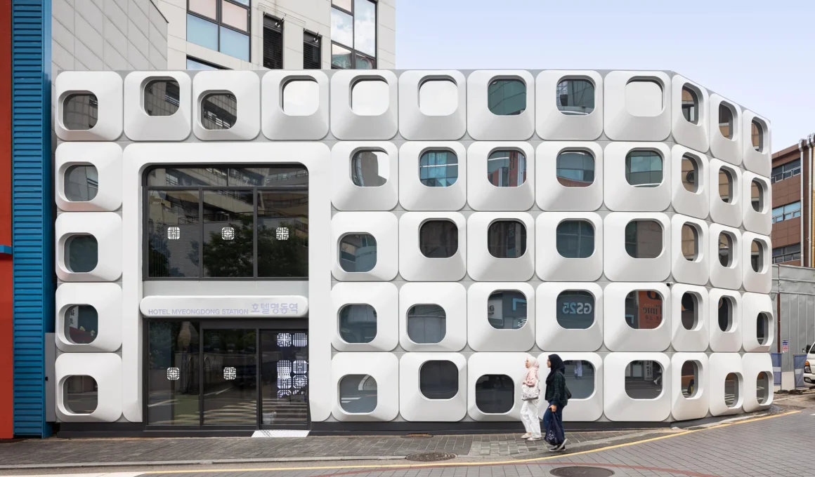 The front elevation of Hotel Myeongdong Station by Yong Ju Lee Architecture featuring white modular vacuum-formed facade panels.