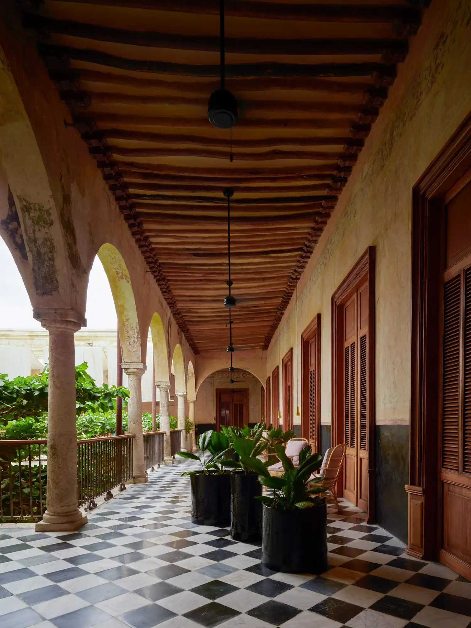 Cloistered corridor at Hotel Sevilla featuring black and white checkered floors.