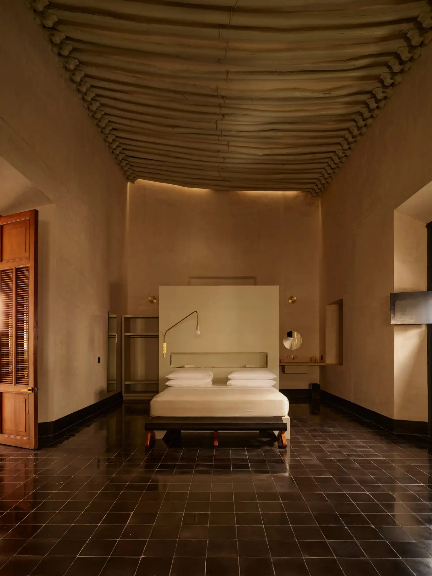 Spacious suite at Hotel Sevilla with high wood-beamed ceilings and black ceramic tile floors.