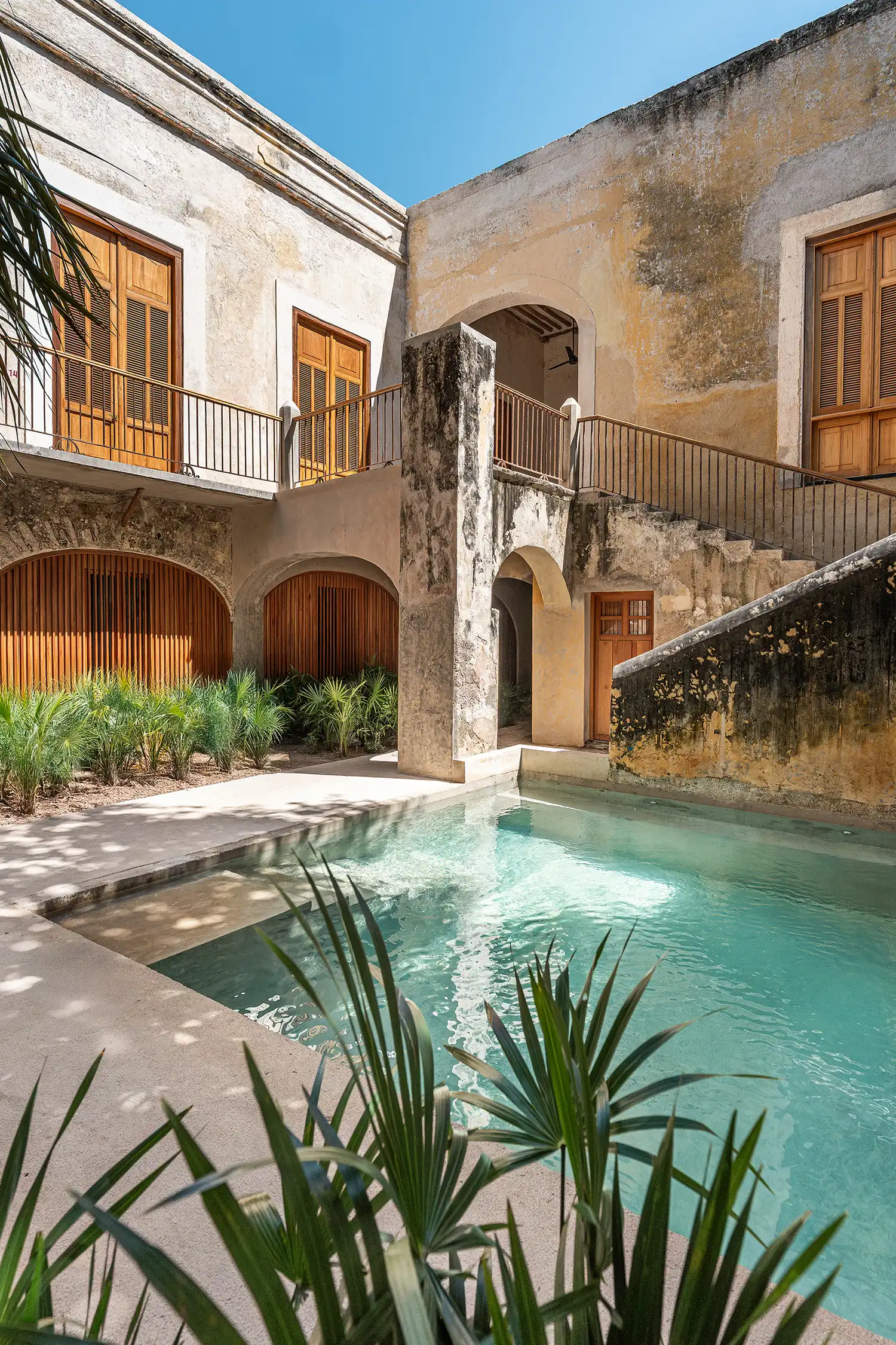 Sunny poolside view at Hotel Sevilla showing the transition between historic stone and new concrete.