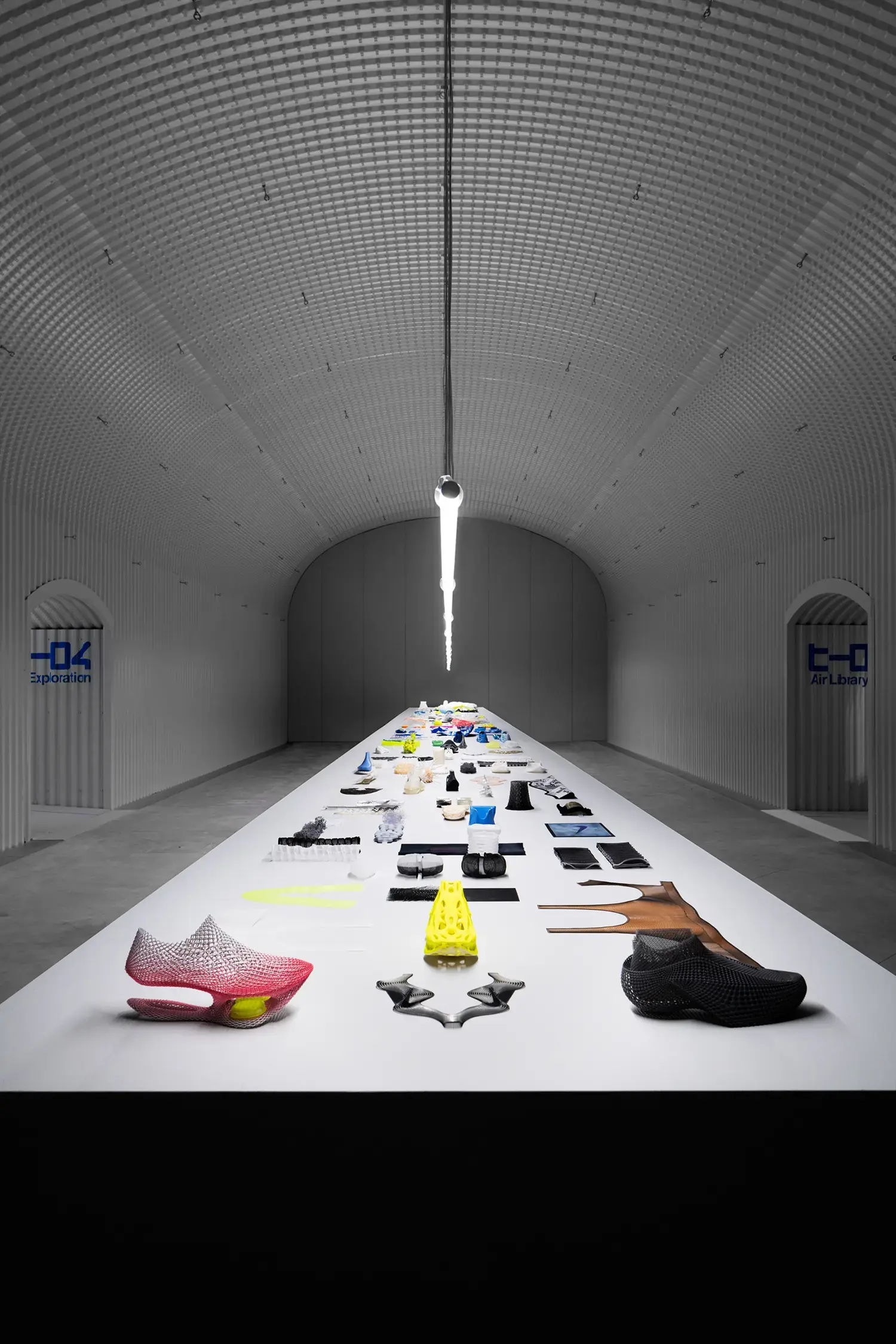 Internal perspective of an industrial tunnel with illuminated tables displaying Nike Airlab technical materials.