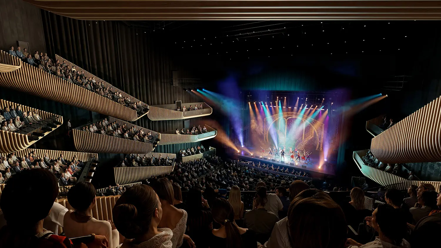 Interior of a dark theater with warm, wood-clad tiered balconies overlooking a brightly lit stage with performers.