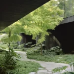 Low-angle view of a stone pathway winding through a lush garden beneath the dark timber undercroft of House in a Garden.