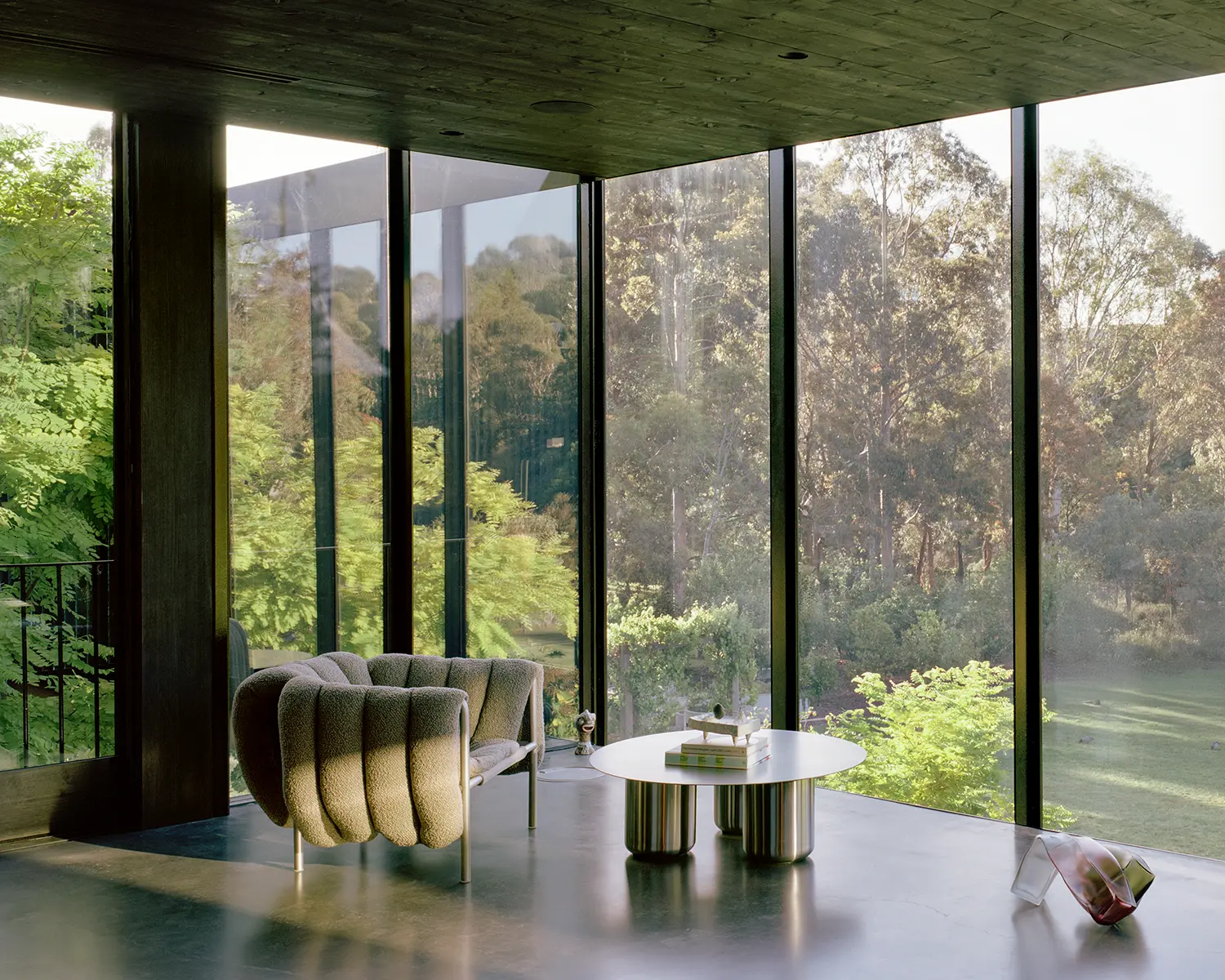Lounge area with floor-to-ceiling windows overlooking a green landscape in Kew.