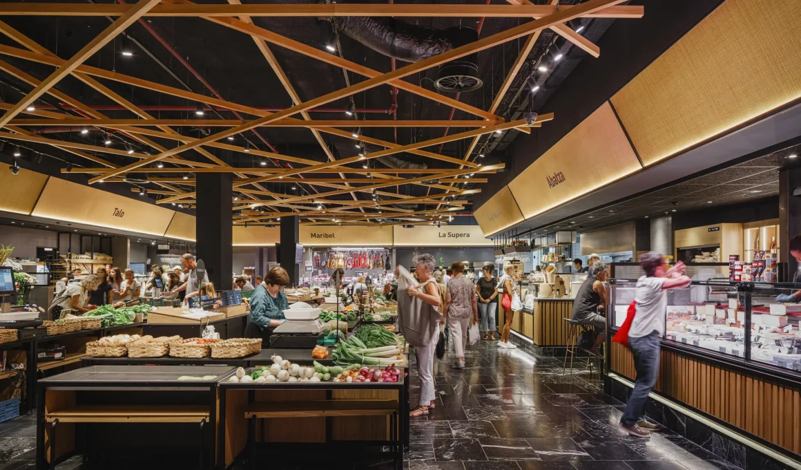 Interior view of San Martin Market featuring a crisscross woven timber ceiling structure over fresh produce stalls.