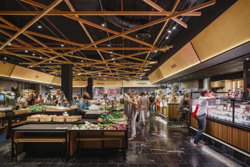 Interior view of San Martin Market featuring a crisscross woven timber ceiling structure over fresh produce stalls.