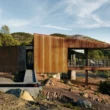 A cantilevered Corten steel house with a concrete entry ramp and water basin in California.
