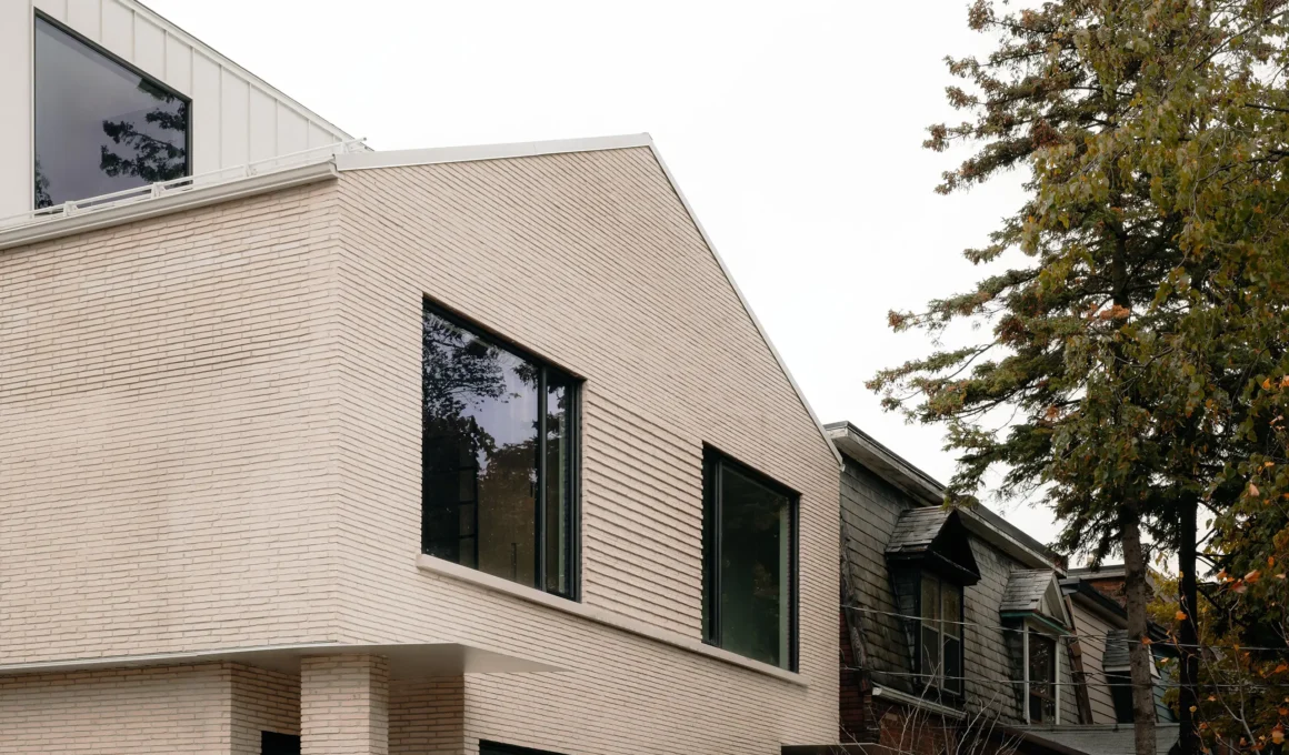 Exterior detail of the Montrose Sixplex street-facing building showing Belgian buff brick and gabled roofline.