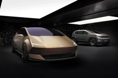 Two Hyundai IONIQ concept cars, the gold VENUS sedan and grey EARTH SUV, displayed in a dark studio with a starry background.