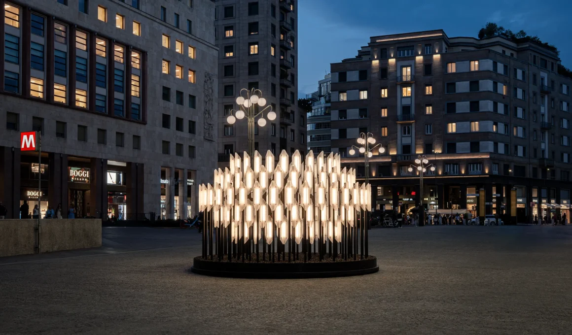 A monumental circular lighting installation glowing in Piazza San Babila at dusk.