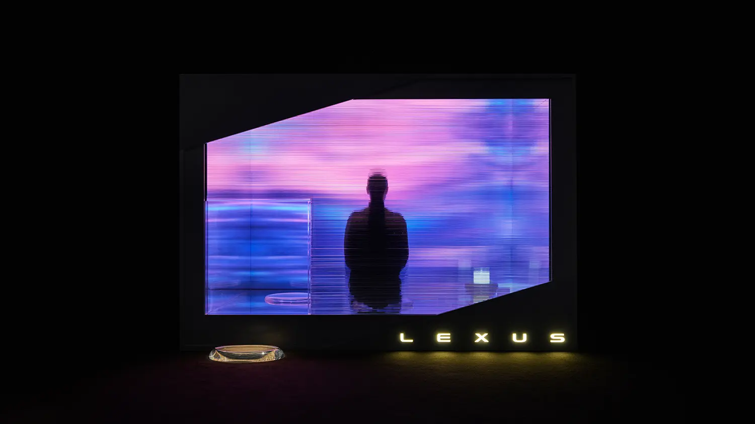 A silhouette of a person sitting in a meditative pose behind a translucent, purple-streaked screen with Lexus branding.