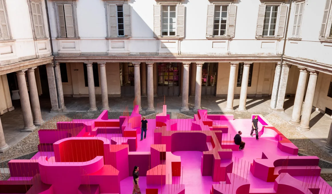 High-angle view of Lina Ghotmeh's pink labyrinth installation in the stone courtyard of Palazzo Litta.