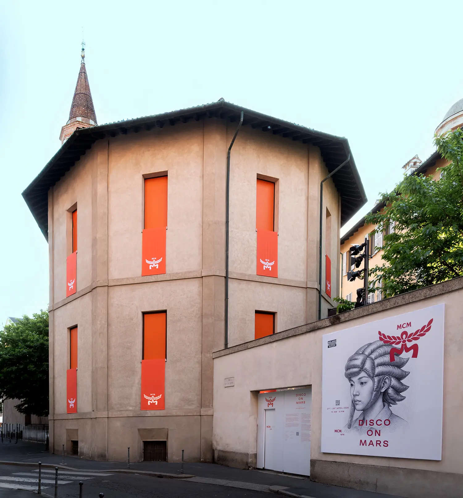 The exterior of a stone rotunda building with orange banners and a large "Disco on Mars" poster.