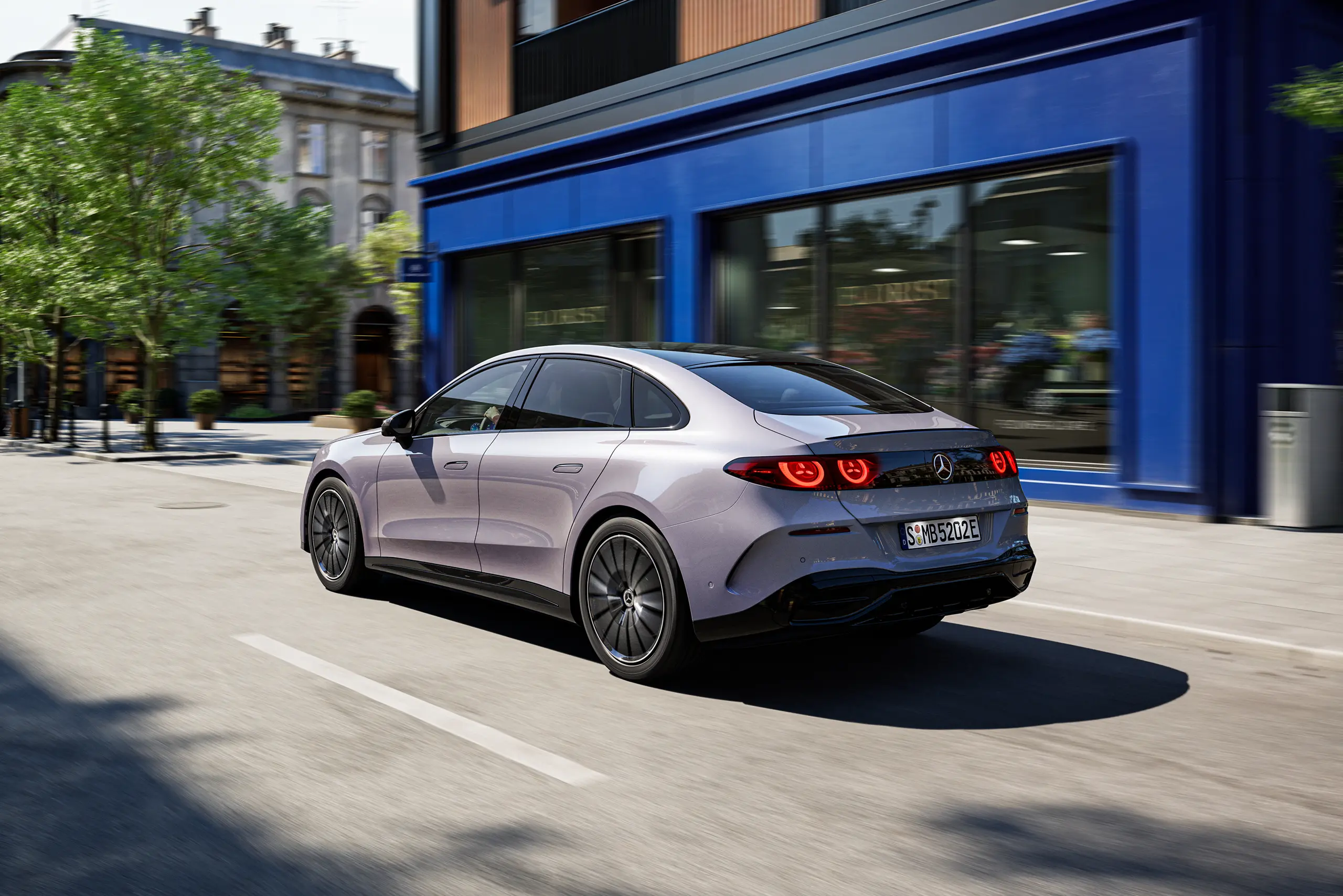 Rear three-quarter view of the electric C-Class showing the distinctive circular LED taillight design.