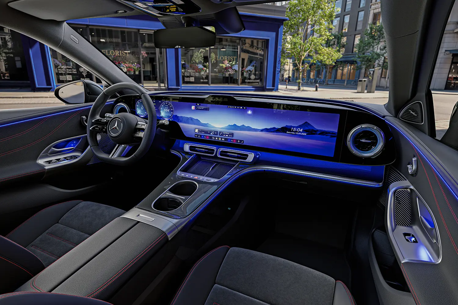 Interior overview with MBUX Hyperscreen displaying landscape graphics and blue ambient lighting.
