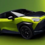Front three-quarter view of the Nissan Juke EV in lime green and black, featuring low-poly faceted body panels and sharp geometric headlights.