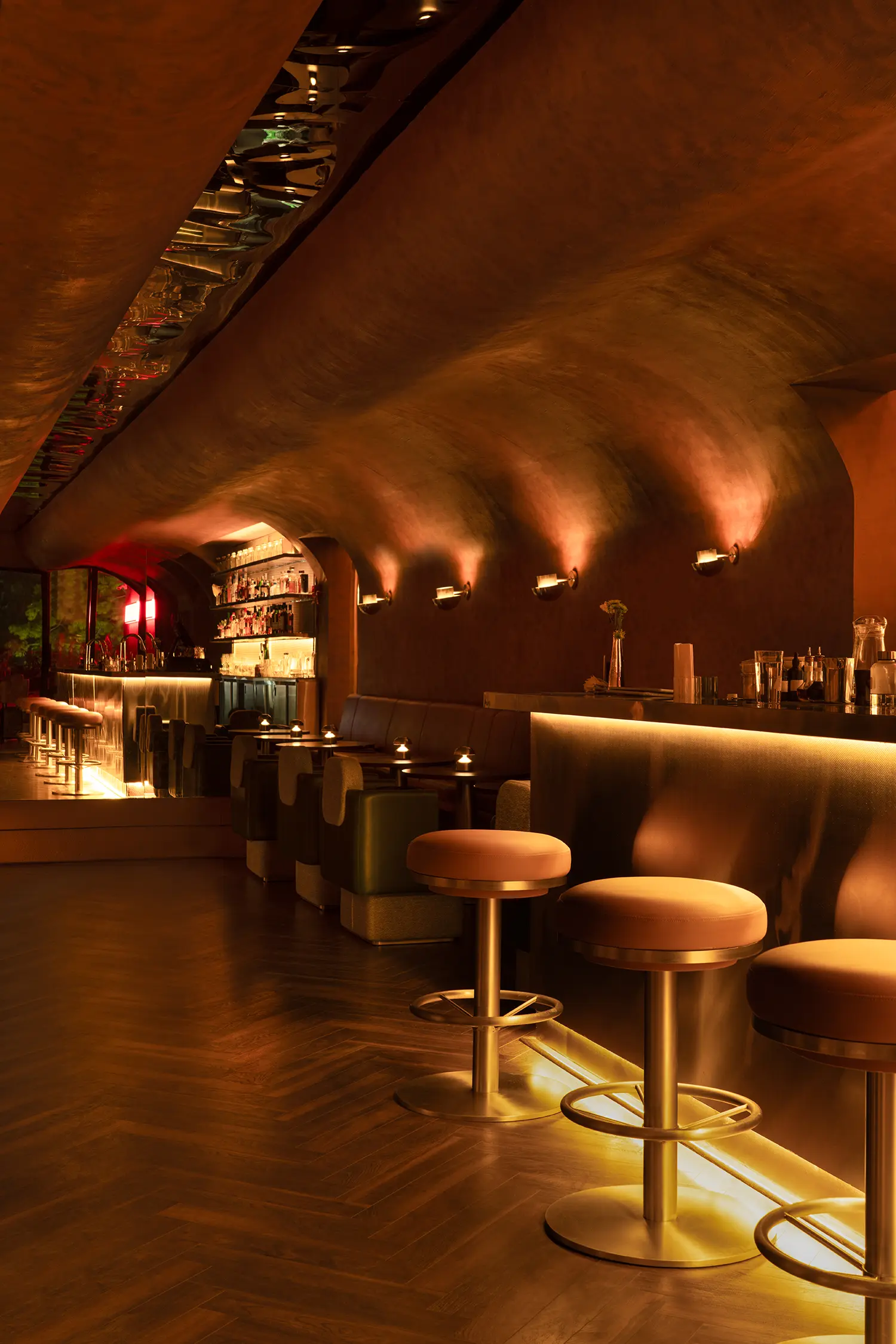 Warmly lit interior of No Vacancy bar with a focus on the rhythm of the seating and the reflective ceiling.