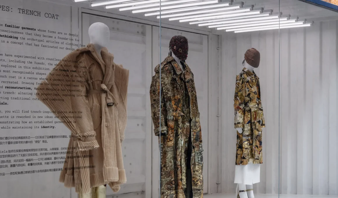 Close-up of Maison Margiela couture garments inside a white shipping container with overhead fluorescent lighting.